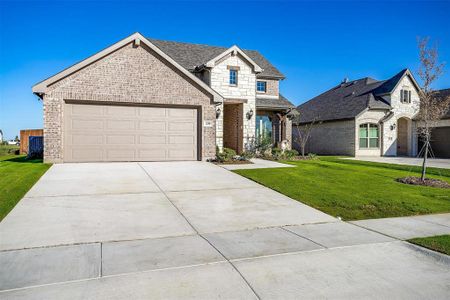 View of front of property with a garage and a front lawn