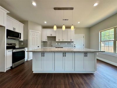 Kitchen featuring appliances with stainless steel finishes, dark hardwood / wood-style flooring, and decorative backsplash