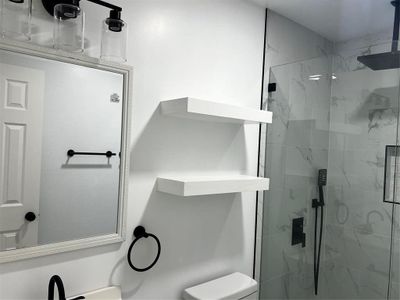 Bathroom featuring an enclosed shower and toilet