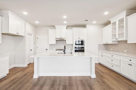 Kitchen featuring appliances with stainless steel finishes, a kitchen island with sink, dark hardwood / wood-style floors, and white cabinets