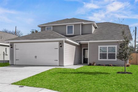 Traditional-style home with a garage, driveway, a front lawn, and roof with shingles