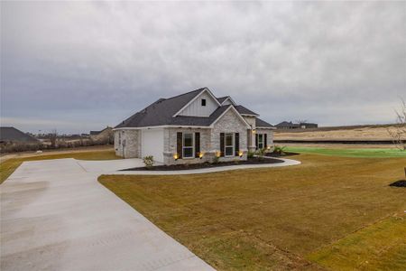 View of front of house with a garage and a front lawn