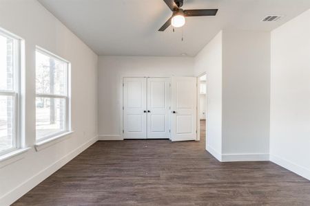 Unfurnished bedroom with dark hardwood / wood-style floors, ceiling fan, and a closet