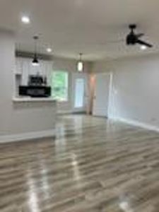 Living room with wood-style flooring and ceiling fan