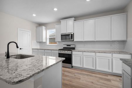 This kitchen is sure to please! With large island, white 42" upper cabinets, dallas white granite, and attractive tile backsplash.