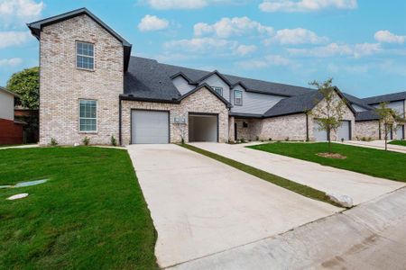 French provincial home with a garage and a front lawn