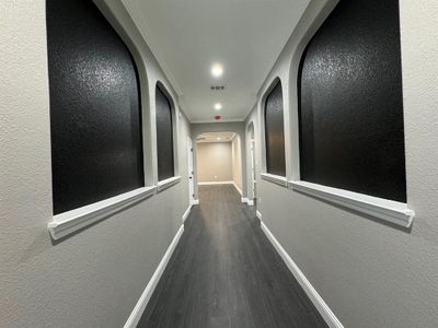 Hallway with dark hardwood / wood-style floors and ornamental molding