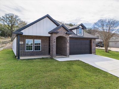 View of front of property with a front yard and a garage