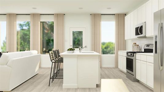 Kitchen with a wealth of natural light, a center island with sink, white cabinets, and appliances with stainless steel finishes