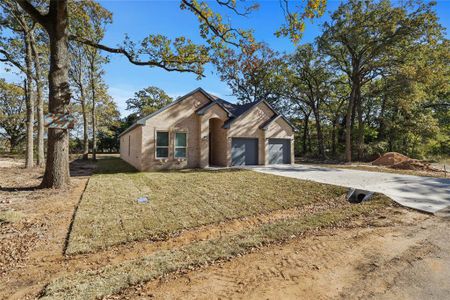 Ranch-style home with a garage and a front lawn