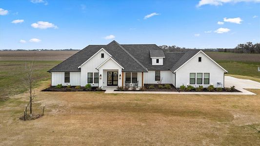 Modern inspired farmhouse featuring a rural view and a front lawn