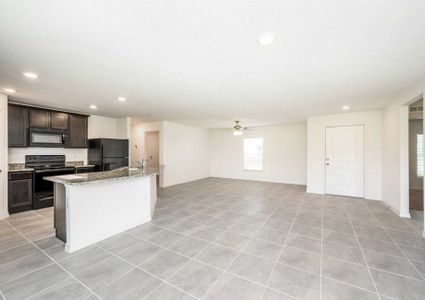 Large living room area with a view of the kitchen and the front door in theÂ Caladesi floor plan.