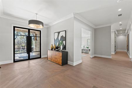 Custom hand sawn white oak floors with beautiful borders and patterned entry. To the right of the entry is the gameroom and media room.