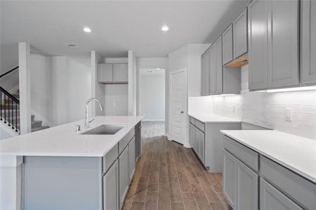 This kitchen is by far any chef’s dream! This spacious kitchen features high ceilings, light stained wood cabinets, quartz countertops, SS appliances, modern tile backsplash, recessed lighting, extended counter space for breakfast bar, and a walk-in pantry all overlooking your huge family room.