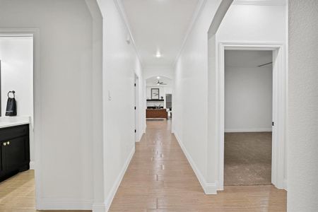 Hallway featuring crown molding and light carpet