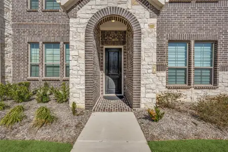 Doorway to property featuring brick siding and stone siding