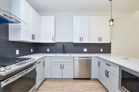 SS appliances. Super nice slide-in gas range. Built in microwave. Energy efficient SS dishwasher. Quartz countertops. Black designer back splash.