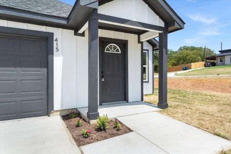 Entrance to property with a garage and a yard