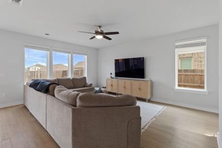 Living area featuring ceiling fan, light wood-style tile flooring