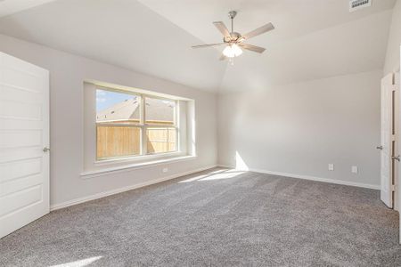 Carpeted spare room with vaulted ceiling and ceiling fan