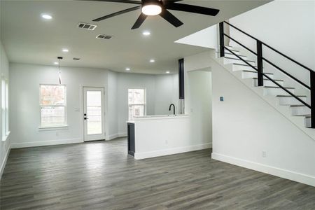 Unfurnished living room with dark hardwood / wood-style floors, sink, and ceiling fan