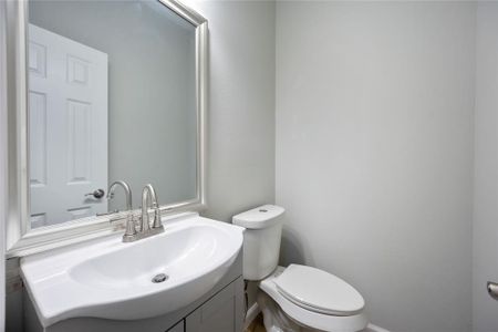 This photo showcases a modern bathroom with a sleek white sink, a stylish mirror, and a contemporary toilet, all set against light-colored walls for a clean and fresh look.