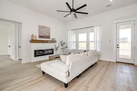 Living area featuring visible vents, recessed lighting, light wood-style floors, baseboards, and ceiling fan