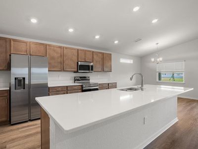 This beautiful home features a bright and open kitchen with quartz countertops, 36-inch birch wood cabinets, and a walk-in pantry.