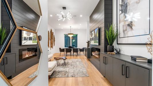 Living room with light wood-type flooring and an inviting chandelier