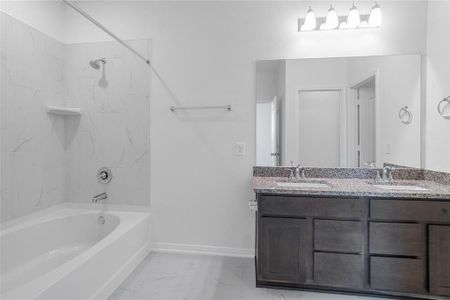 This primary bathroom is definitely move-in ready! Featuring a tub/shower combo with tile surround, stained cabinets with granite countertops, spacious walk-in closet with shelving, high ceilings, custom paint, sleek and modern finishes.