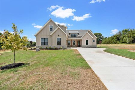 Modern farmhouse style home featuring a front lawn