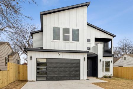 View of front facade featuring a garage and a balcony