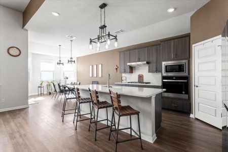 Kitchen featuring a kitchen island with sink, a sink, visible vents, light countertops, and appliances with stainless steel finishes