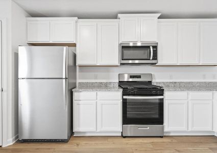 The kitchen is sure to impress with white cabinetry and granite countertops.