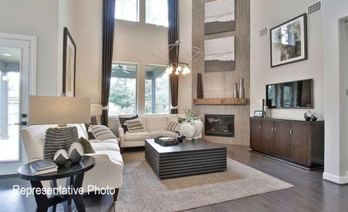 Living room with a fireplace, a high ceiling, and hardwood / wood-style floors