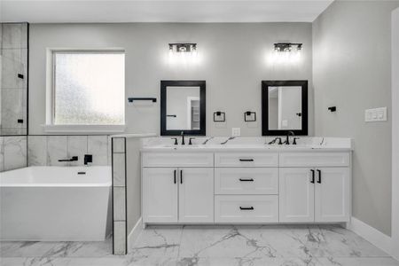 Bathroom with dual vanity, tile patterned flooring, and a bathing tub