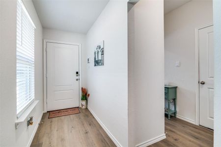 Doorway to outside with baseboards and wood finished floors