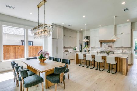 Dining space with sink, light hardwood / wood-style flooring, and a chandelier