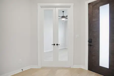 Entrance foyer with light wood-type flooring, baseboards, a ceiling fan, and french doors