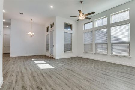 Living room & dining area featuring ceiling fan in living room, Chandelier over dining area, high ceilings with modern canned lighting