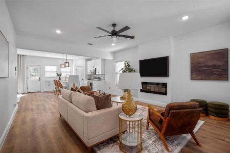 Living room with hardwood / wood-style flooring, ceiling fan, and a healthy amount of sunlight