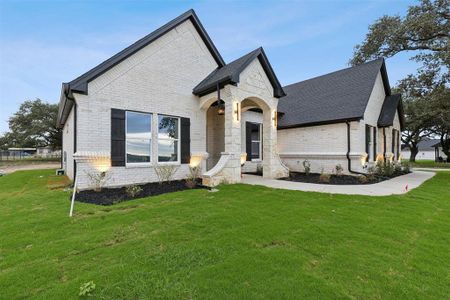 French country inspired facade featuring a front lawn