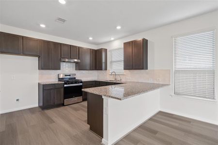 This kitchen is by far any chef’s dream! This spacious kitchen features high ceilings, wood stained cabinets, granite countertops, SS appliances, modern tile backsplash, recessed lighting, extended counter space for breakfast bar, and a walk-in pantry all overlooking your huge family room.