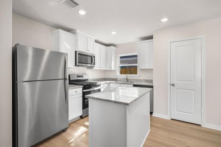 Stainless Steel appliances with white cabinets, along with a breakfast bar.