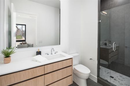 Bathroom with tile patterned floors, a shower with door, vanity, and toilet