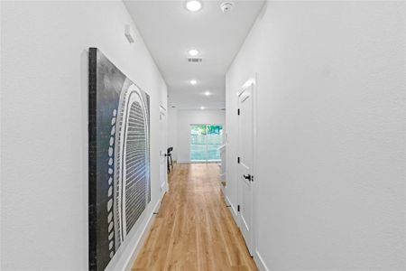 Corridor with light hardwood / wood-style flooring