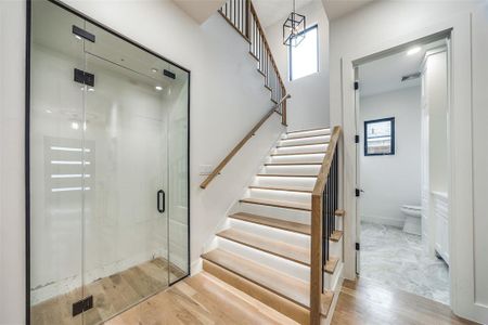 Staircase with hardwood / wood-style flooring and plenty of natural light