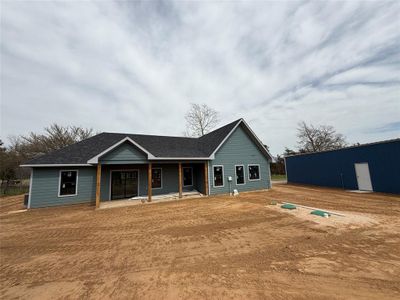 Ranch-style home with covered porch, roof with shingles, and an outdoor structure