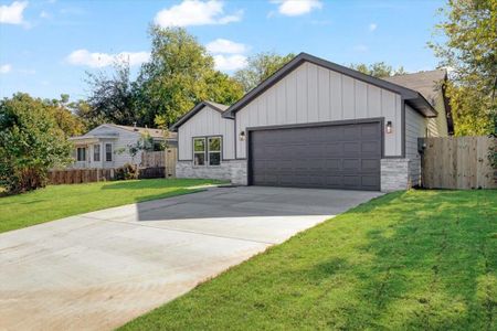 View of front of home featuring a front lawn and a garage