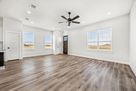 Unfurnished living room featuring hardwood / wood-style floors and ceiling fan